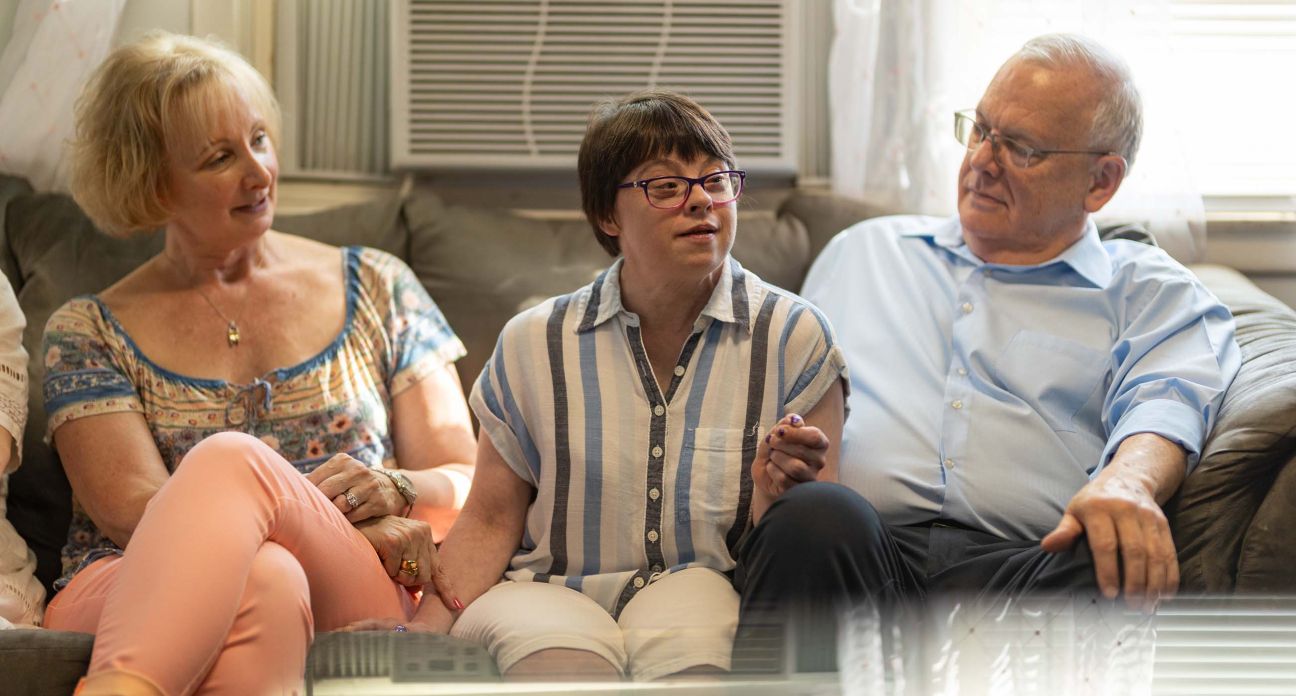 Three people talking on a sofa